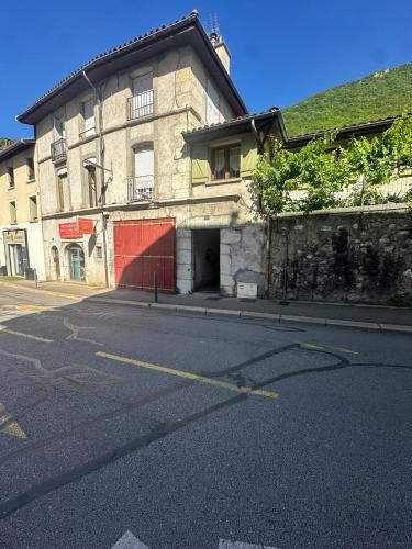 une rue vide devant un bâtiment avec une porte rouge dans l'établissement Joli T3 Proche de l'hôpital, à La Tronche