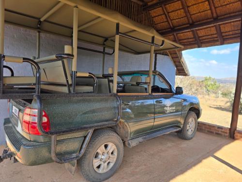 a pick up truck with an open back parked under a building at Milkwood Safari Lodge in Warmbaths