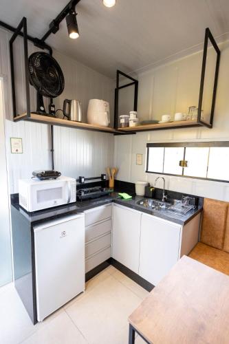 a small kitchen with white cabinets and a sink at Studio 7 completo com Wifi no 1º Andar Novo in Curitiba