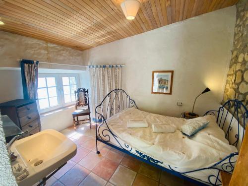 - une chambre avec un lit, un lavabo et une baignoire dans l'établissement La Grange Vercors, à Les Maillets