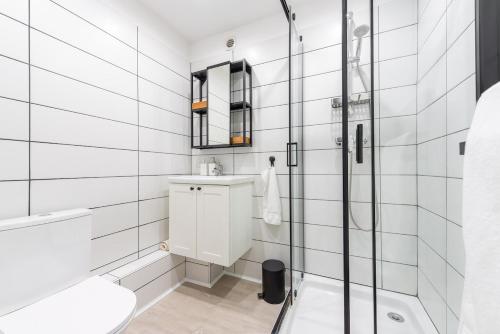 une salle de bain blanche avec une douche et un lavabo dans l'établissement Cozy studio in CapBrun, à Toulon