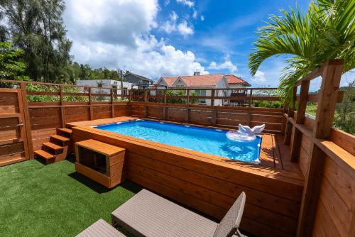 a swimming pool on a deck with a wooden fence at Belle Jung Villa Onna in Onna