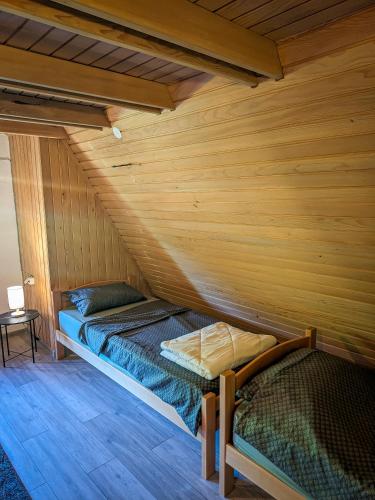 a bed in a room with a wooden wall at Vikendica Stella in Bihać