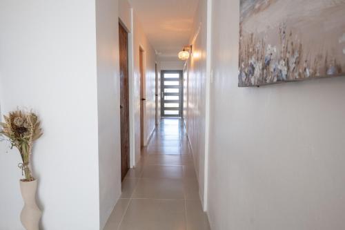 a hallway with white walls and a painting on the wall at Oceanfront Retreat w- Terrace, Direct access to Beach & BBQ in Mayaguez