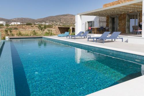 a swimming pool with blue water in a house at ELEONAS Paros estate - villas with private pools OR jacuzzi & professional tennis court in Kampos Paros