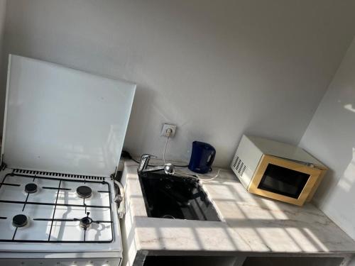 a small kitchen with a stove and a microwave at Les Appartement meublés BELLE et BEAU à Yaoundé Ngousso , lieu dit, deux étages in Yaoundé