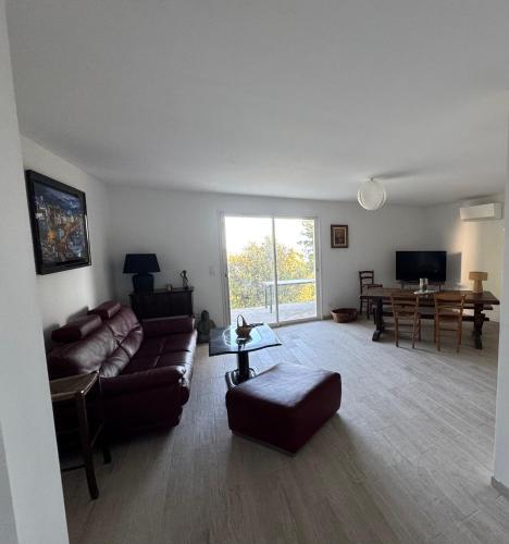a living room with a couch and a table at REZ de VILLA Entre Mer et Maquis Appartement indépendant in Coti-Chiavari