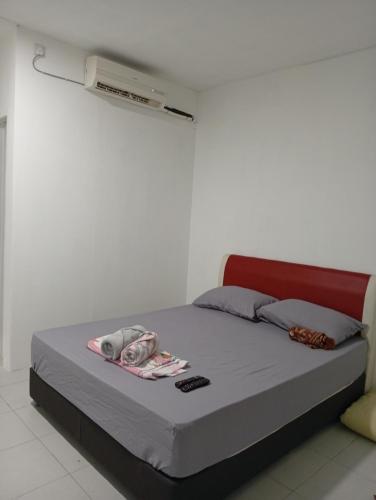 a bed in a white room with avertisementatronatronstrationstrationstration at RoomStay Changloon Berhawa Dingin dan Privasi Penuh in Changlun