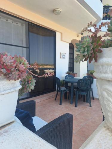 a patio with a table and chairs and a table at Seafront Maisonette Ocean Views & Terrace in Mellieħa