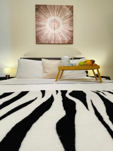 a bed with a black and white rug and a table at Seafront Maisonette Ocean Views & Terrace in Mellieħa