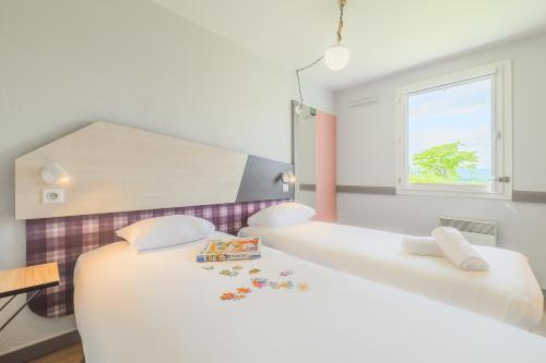 a bedroom with two beds and a window at greet hôtel Annecy Cran-Gevrier by Accor in Annecy