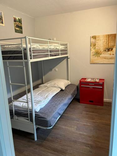 a bedroom with a bunk bed and a red table at App 624 Panoramic Hohegeiß Terrassenhaus in Braunlage