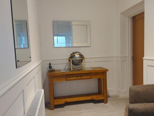 a room with a wooden table with a mirror at Meadow View Apartments in Newquay