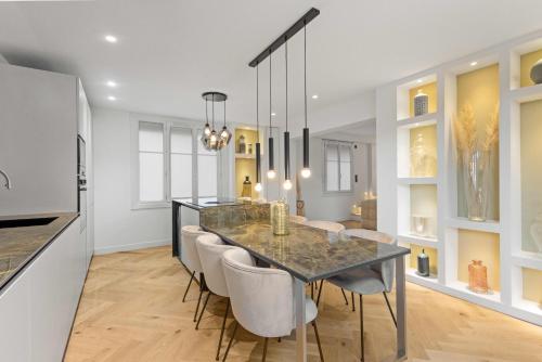 une cuisine et une salle à manger avec une table et des chaises dans l'établissement Luxueuse Villa L'Olivier Cannes 4 chambres jacuzzi, à Cannes