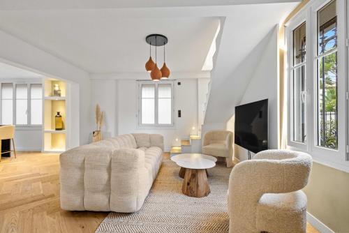 un salon avec un canapé et deux chaises et une télévision dans l'établissement Luxueuse Villa L'Olivier Cannes 4 chambres jacuzzi, à Cannes