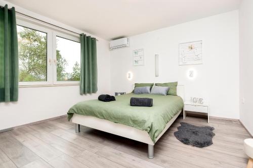 a bedroom with a large bed and green curtains at Apartman Babich in Rovinj
