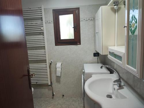 a bathroom with a sink and a mirror and a window at Casetta STELLA MARINA PUNTA SABBIONI in Cavallino-Treporti