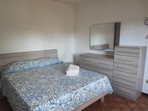 a bedroom with a bed and a dresser and a mirror at Casetta STELLA MARINA PUNTA SABBIONI in Cavallino-Treporti