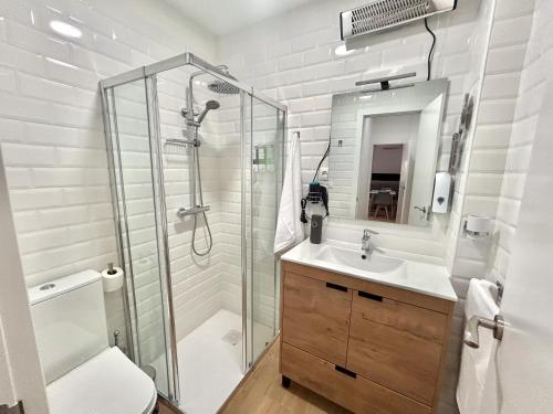 a bathroom with a shower and a toilet and a sink at Apartalux Sevilla Camas in Camas