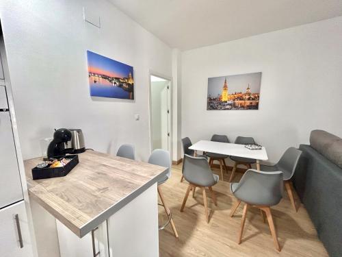 a living room with a kitchen and a table and chairs at Apartalux Sevilla Camas in Camas