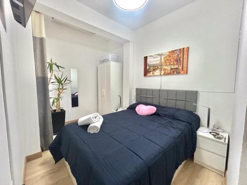 a bedroom with a blue bed with two pink pillows at Apartalux Sevilla Camas in Camas