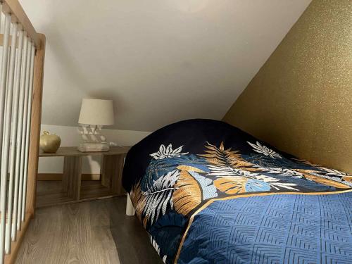 een slaapkamer met een bed met een kleurrijke deken erop bij Séjour à la campagne - Logement cosy et chaleureux in Courgains