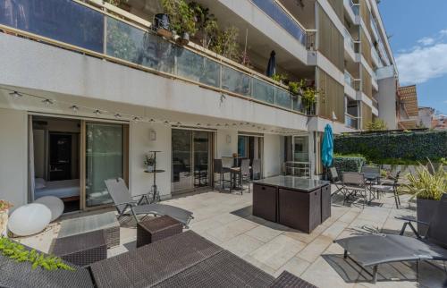 un patio extérieur avec des chaises et des tables ainsi qu'un bâtiment dans l'établissement Luxueux 3 Chambres Terrasse de 90m hypercentre - Wifi Clim - 6 pers, à Cannes