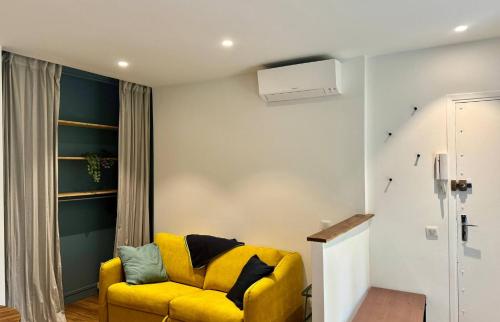 un salon avec un canapé jaune dans une pièce dans l'établissement 2 pièces Hyper-centre Carabacel NICE, à Nice