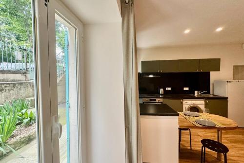 une cuisine avec un comptoir, une table et une fenêtre dans l'établissement 2 pièces Hyper-centre Carabacel NICE, à Nice