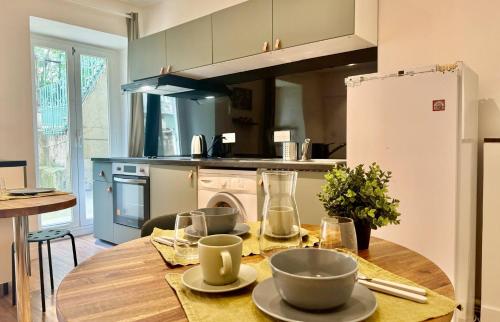 - une cuisine avec une table en bois et des bols dans l'établissement 2 pièces Hyper-centre Carabacel NICE, à Nice