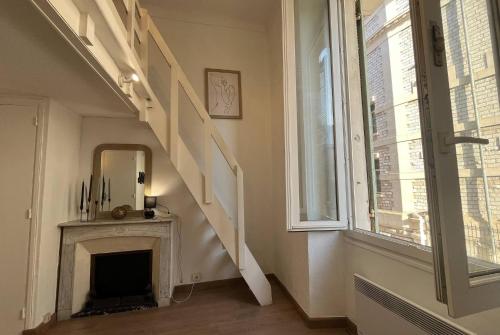 un escalier dans une pièce avec un miroir et une cheminée dans l'établissement Studio Nice Masséna - Coulée Verte, à Nice