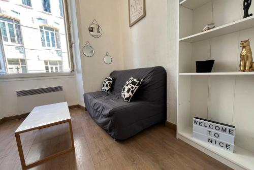 un salon avec un canapé noir et une table dans l'établissement Studio Nice Masséna - Coulée Verte, à Nice