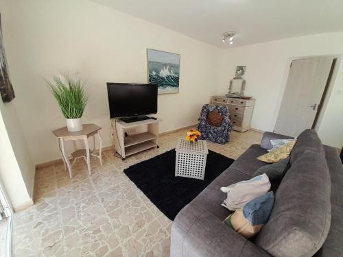 a living room with a couch and a flat screen tv at Cozy Seaview Apartment Sliema S6 in Sliema