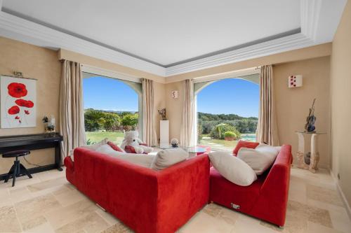 - un canapé rouge dans le salon doté de fenêtres dans l'établissement Prestigious Villa in Mougins 6 bedrooms spa cinema and nightclub, à Mougins