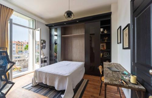 une chambre avec un lit, une table et une fenêtre dans l'établissement Magnifique 2 chambres Centre Cannes - 4 personnes - WIFI Terrasse, à Cannes