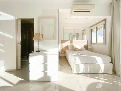 une chambre blanche avec un lit et un miroir dans l'établissement Le ROUAZE studio - proche Carlton et Martinez - idéal congrès - Wifi Clim, à Cannes