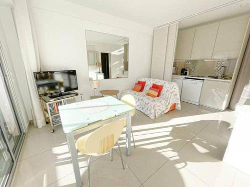 un salon avec une table et un canapé dans l'établissement Le ROUAZE studio - proche Carlton et Martinez - idéal congrès - Wifi Clim, à Cannes