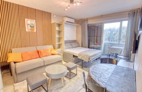un salon avec un canapé et une table dans l'établissement Studio Antibes Centre ville - Parking WIFI Climatisation - LIMESTAY, à Antibes