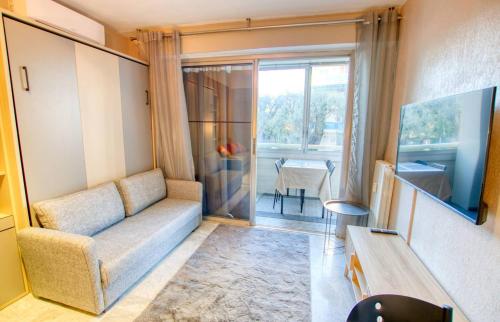 un salon avec un canapé et une table dans l'établissement Studio Antibes Centre ville - Parking WIFI Climatisation - LIMESTAY, à Antibes