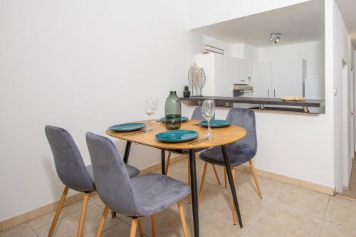 une salle à manger avec une table et quatre chaises dans l'établissement Élégance au Cœur du Vieil Antibes 2 Chambres climatisation 6 personnes, à Antibes