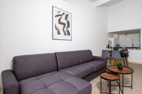 un salon avec un canapé et quelques tables dans l'établissement Élégance au Cœur du Vieil Antibes 2 Chambres climatisation 6 personnes, à Antibes