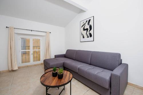 un salon avec un canapé et une table dans l'établissement Élégance au Cœur du Vieil Antibes 2 Chambres climatisation 6 personnes, à Antibes