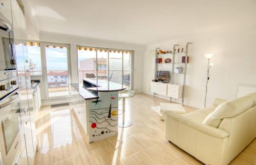 a living room with a white couch and a table at Le Clair Golfe-Juan - T2 terrasse vue mer Parking privé WIFI - LIMESTAY in Golfe-Juan