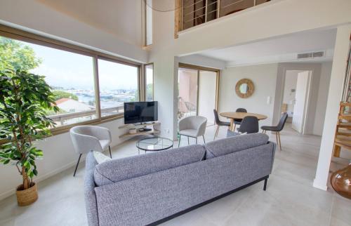 un salon avec un canapé et une table dans l'établissement Duplex Vieil Antibes 3 chambres Parking avec vue mer Wifi - LIMESTAY, à Antibes