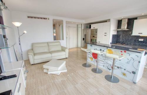 a living room with a couch and a kitchen at Le Clair Golfe-Juan - T2 terrasse vue mer Parking privé WIFI - LIMESTAY in Golfe-Juan
