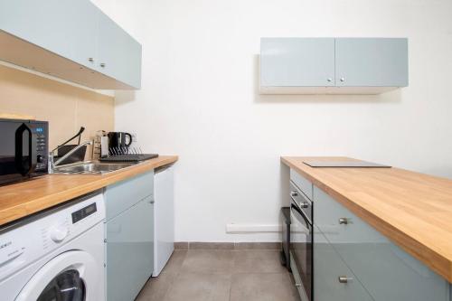 une cuisine blanche avec un lave-linge et un sèche-linge. dans l'établissement Studio Port Golfe-Juan Parking Wifi Climatisation Terrasse, à Vallauris