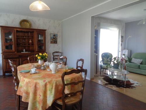 a dining room with a table with flowers on it at chambre d'hôte in Pontorson