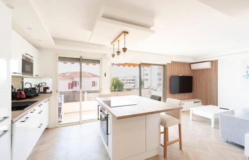 une cuisine avec des placards blancs et une grande fenêtre dans l'établissement Les YUCCAS - 2 pièces Suquet Parking Vue Mer pour 4 personnes, à Cannes