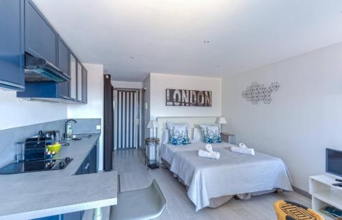 une cuisine et une chambre avec un lit dans une pièce dans l'établissement Le Mimosas - Studio Cannes centre - Vue mer Terrasse WIFI climatisation, à Cannes
