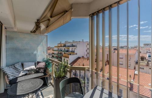 d'un balcon avec un canapé et une vue sur la ville. dans l'établissement Le Mimosas - Studio Cannes centre - Vue mer Terrasse WIFI climatisation, à Cannes